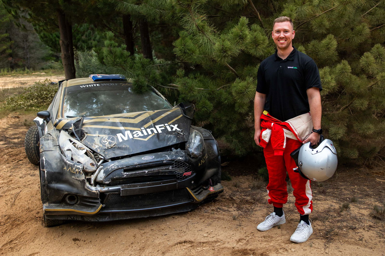 Speedcafe journalist Simon Chapman with the remains of the White Wolf Racing Ford Fiesta R5. Image: Jack Martin