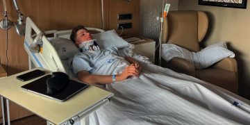 Jacob Roulstone lies in a Spanish hospital wearing a neck brace.